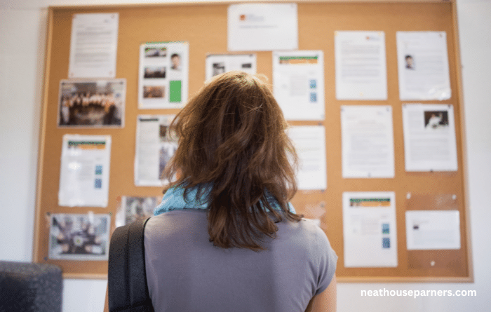 Woman looking at a workplace notice board